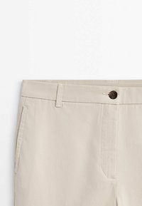 Beige broek met een gladde textuur, voorzien van een knoopsluiting, riemlussen en zijzakken. Eenvoudig ontwerp met een rechte pasvorm.