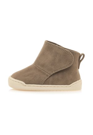 Stivale alla caviglia in suede marrone con suola in gomma bianca, punta arrotondata e manico posterior per una facile calzata. Presenta un risvolto laterale.