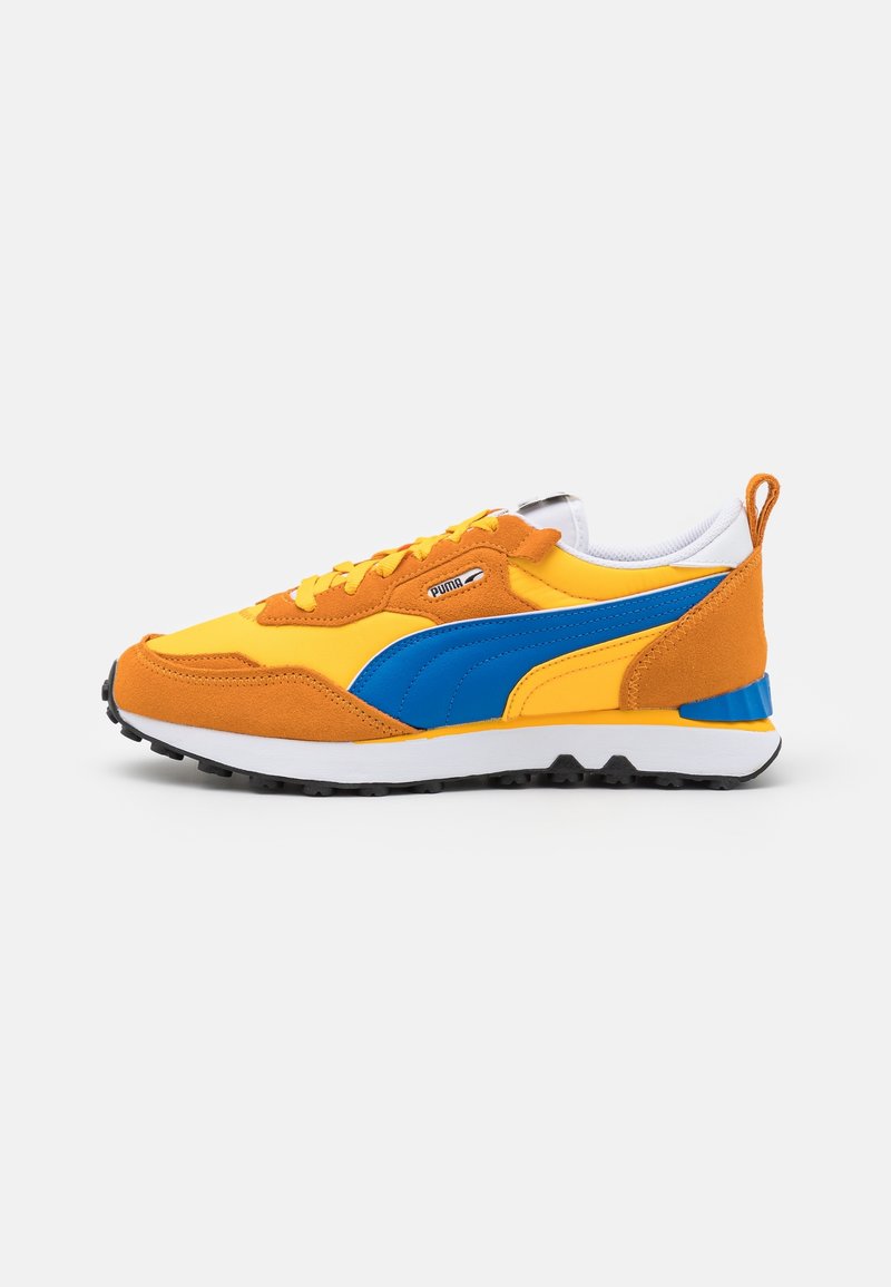 Baskets Puma basses en jaune et orange avec une bande latérale bleue, un col blanc, une semelle noire et une fermeture à lacets, vues de profil.
