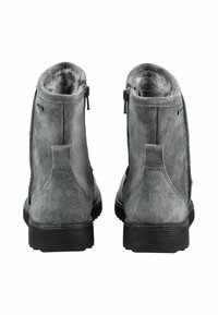 Botines de ante gris con un forro interior suave, cremalleras traseras para facilitar su uso y suelas de goma texturizadas. Diseño simple y funcional.