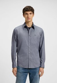 Langsluiting overhemd van gebreide stof in donkerblauw met een subtiel patroon, met een klassieke kraag en knoopsluiting aan de voorkant.
