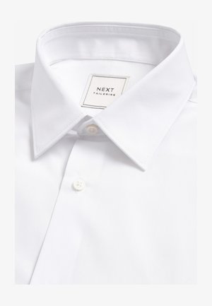 Camicia bianca con bottoni, realizzata in tessuto liscio, caratterizzata da un colletto classico, una chiusura con un solo bottone e un'etichetta con la scritta "NEXT TAILORING".