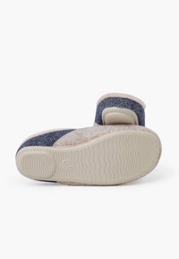 Puchaty, granatowy kapcie z teksturą w jodełkę, jasnoróżowe akcenty i gumowa podeszwa z falistym wzorem zapewniającym przyczepność.