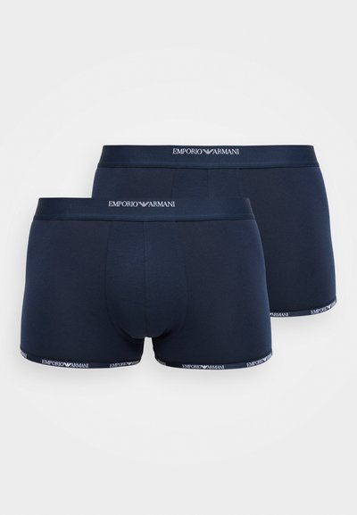 Dziļi zili kokvilnas bokseri ar mīkstu tekstūru, ar kontrastējošu zīmolu joslu, kurā pa malu ir uzraksts "EMPORIO ARMANI".