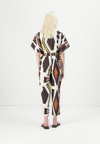 Bunt bedruckter Jumpsuit mit geometrischen Formen in Braun, Weiß, Orange und Pink, mit lockerer Passform und elastischem Bund.