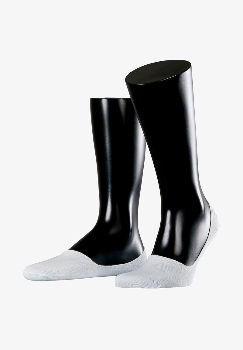 Zwei dunkle Schaufensterpuppen präsentieren hellgraue, unsichtbare Socken mit einer glatten Textur und runder Zehenpartie. Minimalistisches Design und tief ausgeschnittene Form.