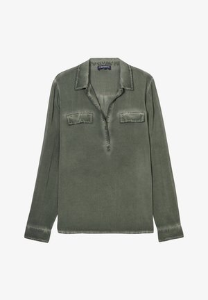 Chemise olive à manches longues en tissu doux, avec un col, deux poches sur la poitrine et une patte de boutonnage. Détails à bords bruts.