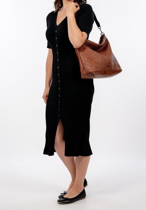 Czarna midi sukienka ryfellowana z krótkimi rękawami i guzikiem z przodu, zestawiona z plecioną brązową torebką i czarnymi balerinami.