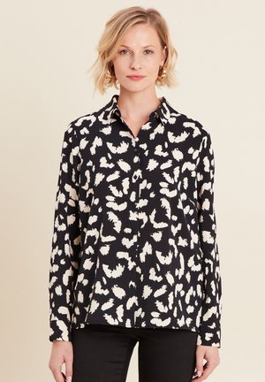 Zwarte button-up shirt met witte abstracte patroon, lange mouwen en een kraag. Zachte stof met een relaxte pasvorm.
