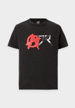 T-shirt noir à manches courtes avec un symbole d'anarchie rouge peint à la bombe et des lettres métalliques argentées "ZR" sur le devant.