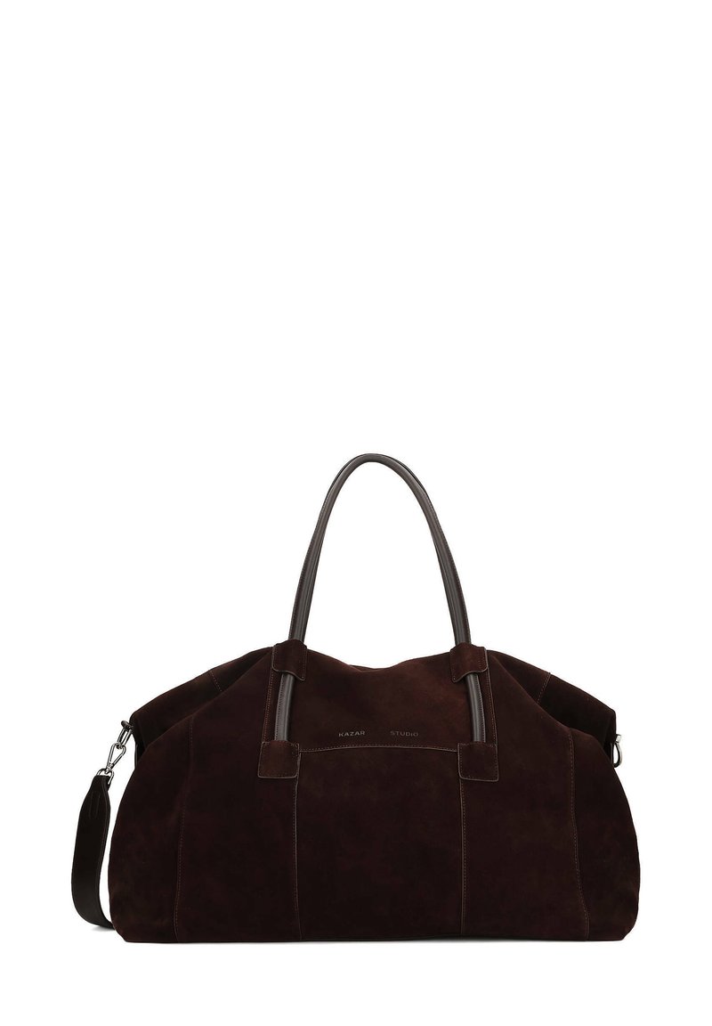 Dark brown suede duffel bag with leather handles and a detachable strap. Features minimal branding and a spacious design. Soft texture.