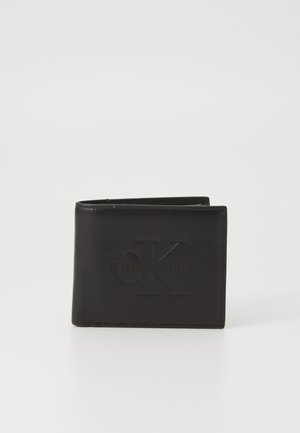 Portefeuille en cuir noir avec logo "CK" en relief, design bi-fold, bords nets et finition texturée. Forme compacte pour un transport facile.