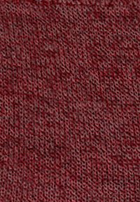 Gros plan sur un tissu rouge tricoté avec des fibres de fil texturées visibles et un motif tissé doux sur toute la surface.