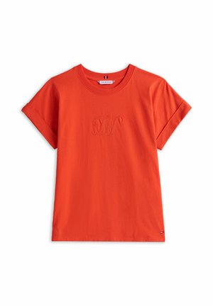 Camiseta naranja de manga corta hecha de algodón. Presenta puños enrollados y un logo bordado tonal en el pecho. Textura suave y ajuste regular.