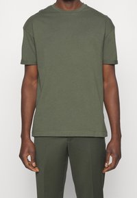 Olivengrøn bomulds T-shirt med rund halsudskæring og korte ærmer. Har en lige pasform og minimalistisk design. Ingen synlige mønstre.