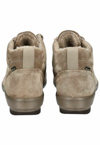 Beige suède enkellaarsjes met een textuur oppervlak, elastische accenten op de hak en rubberen zolen voor grip. Dubbelgestikte naden zichtbaar.