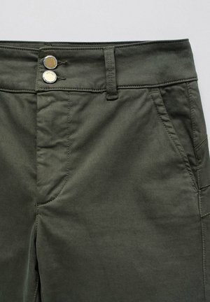 Pantalones de algodón verde oliva con una textura suave, dos botones plateados en la cintura y bolsillos laterales con detalles de costura.