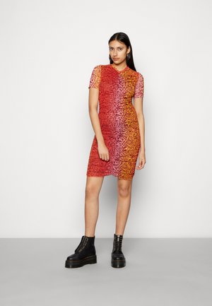 Vestido de mangas curtas com um padrão degradê que vai do rosa ao laranja, apresentando um design texturizado. Combinado com botas pretas de plataforma chunky.