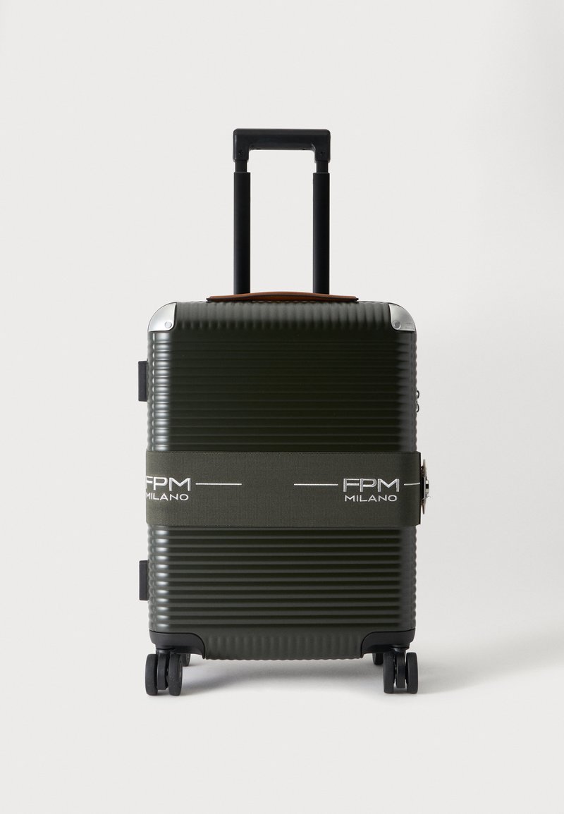 Valise rigide vert foncé à coque striée, avec une poignée déployée, quatre roulettes et une sangle siglée FPM Milano.