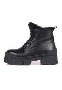 Botines de cuero negro con trim de pelaje sintético en la parte superior, diseño de cordones, suela de plataforma gruesa y suela de goma texturizada.