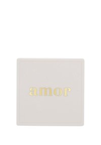Vit fyrkantig låda med en strukturerad yta, med ordet "amor" i guldfolierad text centrerat på framsidan.