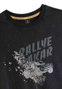 Czarny bawełniany T-shirt z okrągłym dekoltem. Posiada graficzny nadruk samochodu oraz tekst "Rallye Dakar" w odcieniu szarości, z teksturowanym efektem.