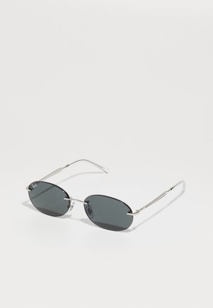 Óculos de sol ovais pretos com lentes escuras, armação em metal e detalhes em prata. Possui hastes finas e almofadas no nariz para suporte.