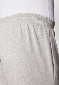 Grå sweatpants med elastisk talje, lavet af et blødt, tekstureret stof, med sidesømme og en afslappet pasform.