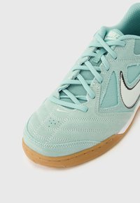 Αθλητικό παπούτσι με συνθετικό επάνω μέρος σε μέντα πράσινο, λεπτομέρειες από δίχτυ, λογότυπο λευκό swoosh και υφή πάτου από καουτσούκ σε χλωμό καφέ. Διαθέτει σχέδιο με κορδόνια.