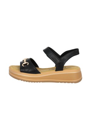 Zwarte leren sandalen met een verstelbare enkelband, goudkleurige hardware en een tan platformzool met groeven voor grip.
