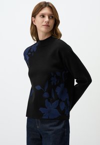 Zwarte trui met lange mouwen, met aan één kant een donkerblauw bloemenpatroon. Hoge nekdesign, zachte textuur en een ontspannen pasvorm.