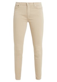 Jeans slim fit beige hechos de una tela suave. Sus características incluyen cinco bolsillos, una cremallera y un cierre de botón metálico. Textura suave en toda su superficie.