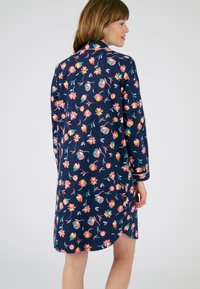 Vestido floral navy de mangas largas, con coloridos patrones florales, un cuello tipo solapa y un dobladillo curvado. Fabricado en una tela suave.