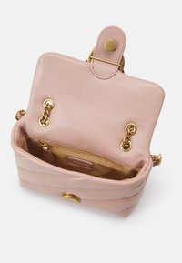 Roze leren handtas met gouden hardware, kettingaccenten en een magnetische klepsluiting. Het interieur heeft een ritszak en een strakke voering.