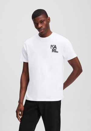 Witte katoenen t-shirt met een zwart grafisch logo "KARL" op de linkerkant van de borst. Korte mouwen en een ronde halsontwerp.