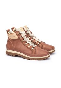 Botas de senderismo de cuero marrón con acentos beige, diseño de cordones, parte superior texturizada, herrajes en tono dorado y suela de goma resistente.