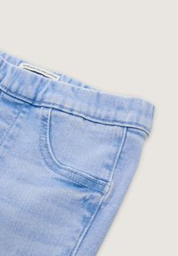 Jasnoniebieskie szorty dżinsowe wykonane z bawełny organicznej. Posiadają przednią kieszeń i szyty pasek. Tekstura wydaje się miękka z delikatnym wyblaknięciem.