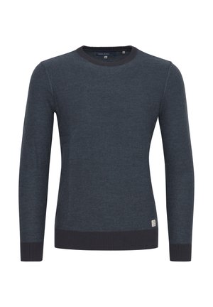 Donkerblauwe trui van zachte stof, met een ronde halslijn, lange mouwen en een donkere ribbelboord bij de manchetten en onderkant. Klein logo-label aan de zijkant.