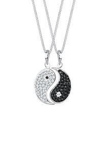 Yin-Yang-Anhänger mit silbernen Ketten. Eine Seite zeigt weiße Kristalle, die andere Seite hat schwarze Kristalle. Glatte Metallelemente.