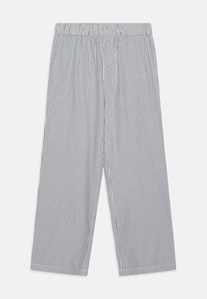 Pantalon large à rayures verticales noires et blanches avec une ceinture élastique, étalé à plat sur un fond blanc.