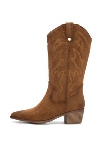 Bota de cowboy de ante marrón con punta afilada, costuras decorativas, un tacón cuadrado y una cinta en la parte trasera para facilitar el uso.