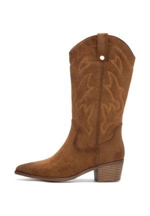 Bota de cowboy de ante marrón con punta afilada, costuras decorativas, un tacón cuadrado y una cinta en la parte trasera para facilitar el uso.