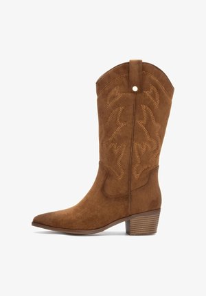 Bota de cowboy de ante marrón con punta afilada, costuras decorativas, un tacón cuadrado y una cinta en la parte trasera para facilitar el uso.