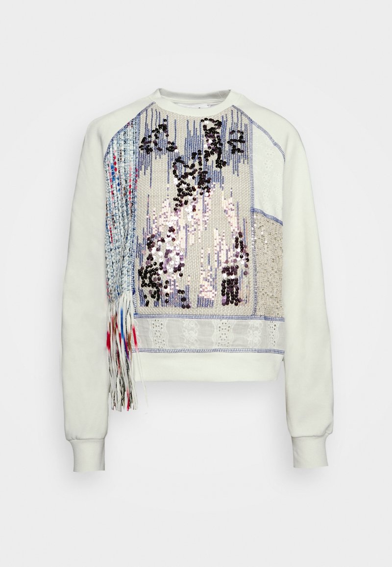 Sweat-shirt blanc à manches longues avec un panneau texturé de sequins bleus, argentés et noirs et des détails à franges sur le côté avant gauche.
