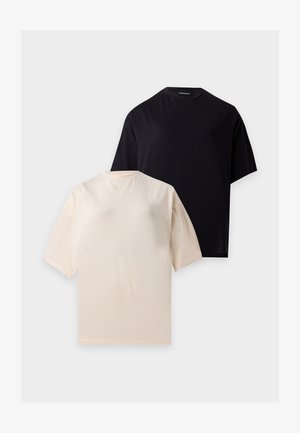Un t-shirt noir et un t-shirt beige uni à manches courtes et col rond, posés à plat sur fond blanc.
