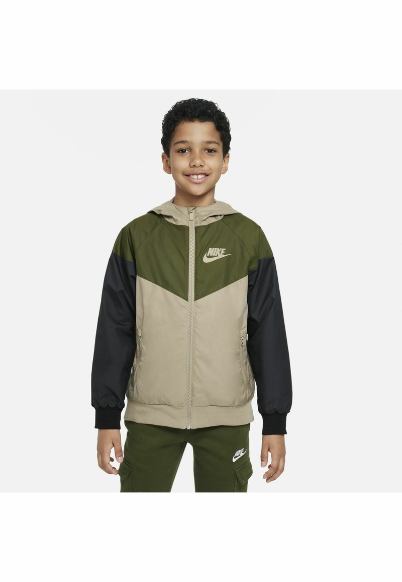 Chaqueta Nike con capucha, diseño a bloques de color en verde oliva, beige y negro, con cierre de cremallera frontal y detalle del logo en el pecho.