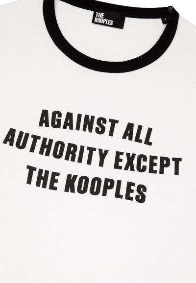Hvid bomulds t-shirt med en sort ribbet rund halsudskæring, der har fed sort tekst: "IMOD AL AUTHORITET BORTSET FRA KOOPLES."