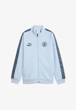 Hellblaues Zip-Jacke mit weißen Akzenten, versehen mit einem Manchester City-Logo und schwarzen gemusterten Seitenelementen, hergestellt aus glattem Material.