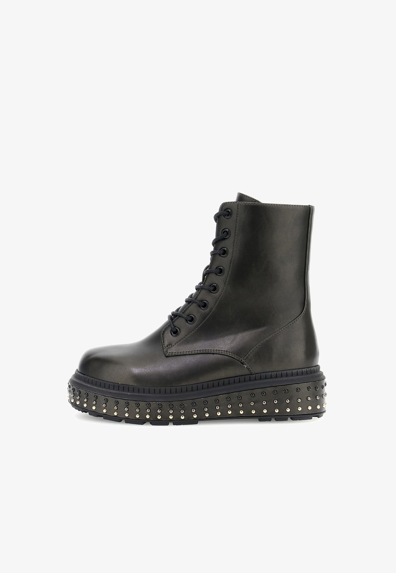 Bota de piel negra hasta el tobillo con diseño de cordones, puntera redonda y suela de plataforma adornada con pequeñas tachuelas doradas a lo largo del borde.