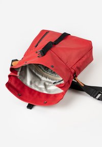 Roter Rucksack mit flachem Design, aus strapazierfähigem Stoff gefertigt. Er verfügt über einen Reißverschluss, verstellbare Träger und ein glattes Innenfutter.